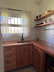 eine Küche mit Spüle und Fenster in der Unterkunft Cabaña para 4 personas, zona centro, vista al Rio Aluminé in Aluminé