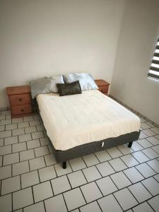 クエルナバカにあるcasa agradableのタイルフロアのベッドルームにベッド1台が備わります。