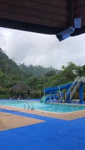 een groot zwembad met een blauwe waterglijbaan bij Alma y Palma Casa Campestre in Pedro Vicente Maldonado