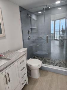 a white bathroom with a shower and a toilet at Steps to the beach and amazing views! in Panama City Beach