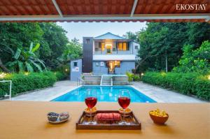 a house with a pool and a table with wine glasses at EKOSTAY - Fern Wood Villa 