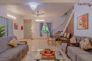 a living room with two couches and a table at EKOSTAY - Fern Wood Villa  +17 photos