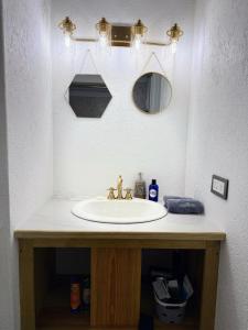 a bathroom with a sink and a mirror at The GRΣΣK Cottage in Kingstown +41 photos