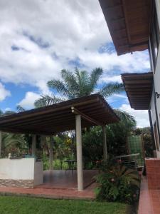 een terras met een parasol, een tafel en een palmboom bij Alma y Palma Casa Campestre in Pedro Vicente Maldonado