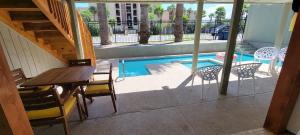 a patio with a table and chairs and a pool at Huge Beach view Home- Heated Spa New Remodel in South Padre Island +92 photos