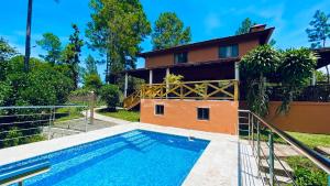a villa with a swimming pool in front of a house at Luxury Villa Heated Pool, Firepit & Pool Table in Arroyo Frío