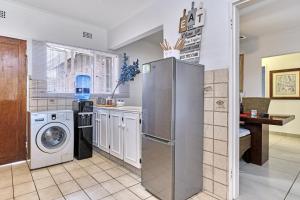 una cocina con nevera y lavadora en Aviator's Nest, en Kempton Park
