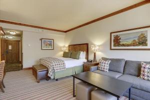 une chambre d'hôtel avec un lit et un canapé dans l'établissement Studio 373 at The Lodge at Spruce Peak, à Stowe Mountain