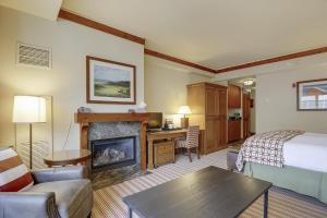 une chambre d'hôtel avec un lit et une cheminée dans l'établissement Studio 373 at The Lodge at Spruce Peak, à Stowe Mountain 20 autres photos