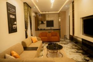 a living room with two couches and a television at Awka Luxury One Bed in Awka