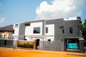 a white and gray house with a fence in front of it at Awka Luxury One Bed in Awka