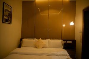 a bedroom with a bed with white sheets and pillows at Awka Luxury One Bed in Awka