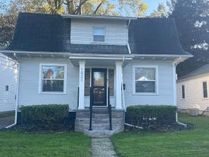 a white house with a black roof at Quiet 3 Bedroom home Near downtown in Lansing