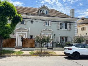a white car parked in front of a white house at Casona Quintamar 6 norte in Viña del Mar