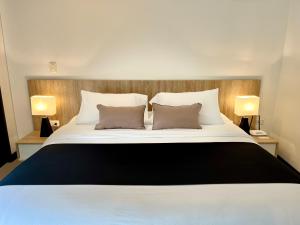 a bedroom with a large white bed with two pillows at Suites - Llanogrande in Rionegro