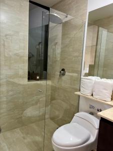 a bathroom with a toilet and a glass shower at Suites - Llanogrande in Rionegro