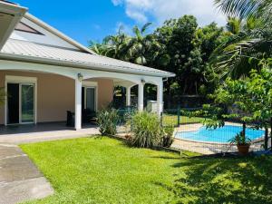 a house with a swimming pool in a yard at Le Calouni entre mer et volcan in Sainte-Rose
