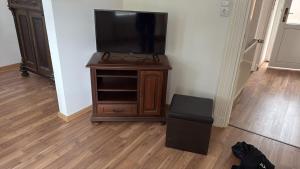 a tv on a wooden stand in a room at Haus Ostfriesland Jemgum in Jemgum