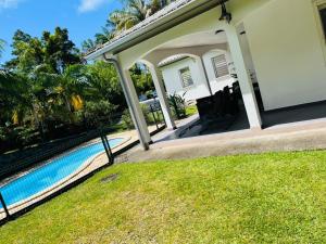 a house with a swimming pool in a yard at Le Calouni entre mer et volcan in Sainte-Rose