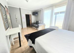 a bedroom with a bed and a chair and a desk at Zhantique Guest House 2- Unit 2 in Boksburg +28 photos