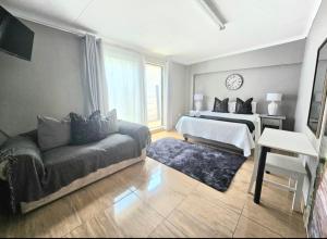 a bedroom with a bed and a couch in a room at Zhantique Guest House 2- Unit 2 in Boksburg