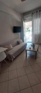 a living room with a bed and a table and a couch at Haras'house in Nei Poroi