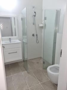 a bathroom with a shower and a sink and a toilet at Beach Suite Israel- Private Jacuzzi Sea View Balcony, Off-Site Spa ביץ סוייט ישראל- ג'קוזי פרטי עם נוף ים, אפשרות לספא מוזל in Ashqelon