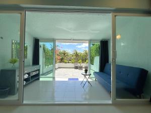 sala de estar con sofá azul y puertas correderas de cristal en Gran Suite Cancun - Beach Condo, en Cancún