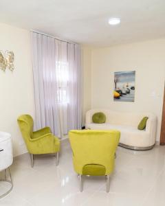 un soggiorno con sedie gialle e un divano di La Isla Royal - Luminancia Eterna a Miches