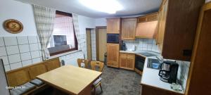 a kitchen with wooden cabinets and a table in it at Casaba Suite 1-110qm-3 Rooms-Free Private Parking-House with garden in Hannover