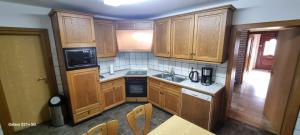 a kitchen with wooden cabinets and a sink at Casaba Suite 1-110qm-3 Rooms-Free Private Parking-House with garden in Hannover