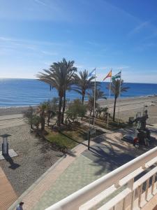 Una vista de una playa con palmeras y el océano. en Primera linea de Playa a 10 min Estepona, en San Luis de Sabinillas