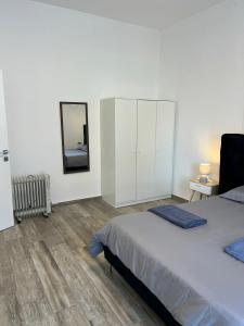 ein weißes Schlafzimmer mit einem Bett und einem Spiegel in der Unterkunft Haifa Charm View in Haifa