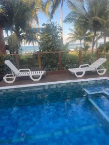 a swimming pool with two lounge chairs next to a swimming pool at Morada DaLuz in Barra Grande