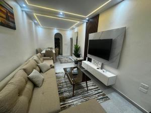 a living room with a couch and a flat screen tv at Moly House in Aswan