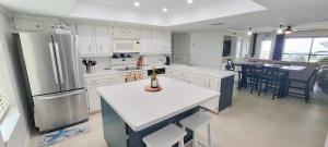 a kitchen with white appliances and a dining room at Top Floor Ultimate Beachfront Luxury Remodeled in South Padre Island