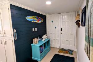a room with a blue wall with a surfboard on the wall at Top Floor Ultimate Beachfront Luxury Remodeled in South Padre Island +136 photos