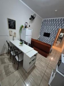 a room with a white table and chairs and a couch at Cozy Home 1 in Boituva