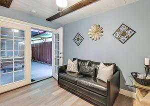 Una sala de estar con un sofá de cuero y una puerta corrediza de vidrio. en Spacious Family Getaway with Grill Firepit and Patio, en San Ysidro