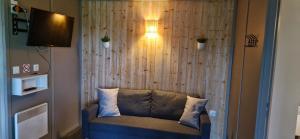a living room with a couch in front of a wall at Chalet JACUZZI/spa privatif PERCE NEIGE in Plombières-les-Bains