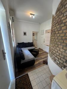a living room with a couch and a brick wall at Prenoćiste Casa Bella & Nova in Palić