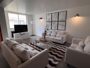 a living room with couches and a flat screen tv at HOTEL LOS NAVEGANTES in Punta Arenas