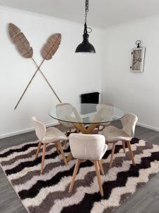 a dining room with a glass table and four chairs at HOTEL LOS NAVEGANTES in Punta Arenas
