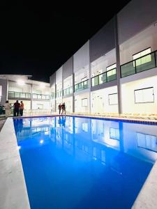 a swimming pool in a building with people in the water at Pousada SB in Campo Formoso