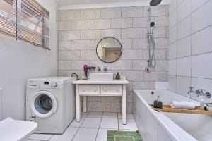 a bathroom with a washing machine and a sink at Clear Skies in Kempton Park