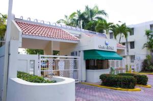 ein weißes Gebäude mit grüner Markise in der Unterkunft Mar Azul Apartments in San Juan