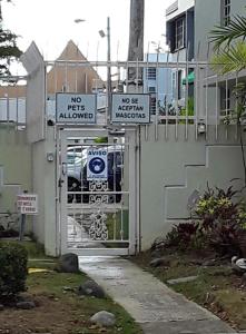 ein Tor mit Straßenschildern vor einem Haus in der Unterkunft Mar Azul Apartments in San Juan