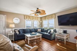 a living room with a blue couch and a flat screen tv at 1 4 Us by Oak Island Accommodations in Oak Island