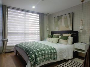 a bedroom with a large bed and a window at Apartment - 2Bedrooms - QueenBed - Balcony - Parking - 7thFLOOR in Quito