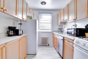 Una cocina con gabinetes de madera y un refrigerador blanco. en Comfy & Relaxing Apt, en Alexandria